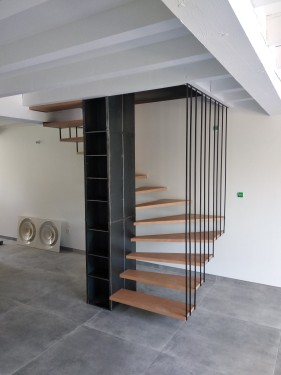 Escalier fer/bois demi tournant suspendu / Marches hêtre vernis / Bibliothèque fer brut patiné / Suspension fer plat brut patiné