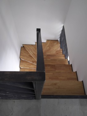 Escalier demi tournant fer brut patiné / marches bois balancées / limon crémaillère
