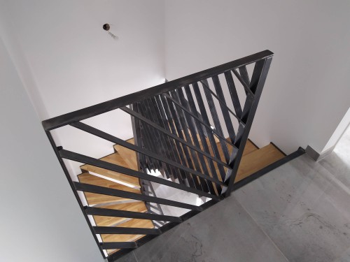 Escalier demi tournant fer brut patiné / marches bois balancées / limon crémaillère