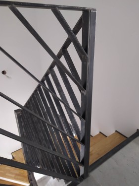 Escalier demi tournant fer brut patiné / marches bois balancées / limon crémaillère