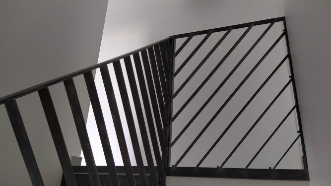 Escalier demi tournant fer brut patiné / marches bois balancées / limon crémaillère